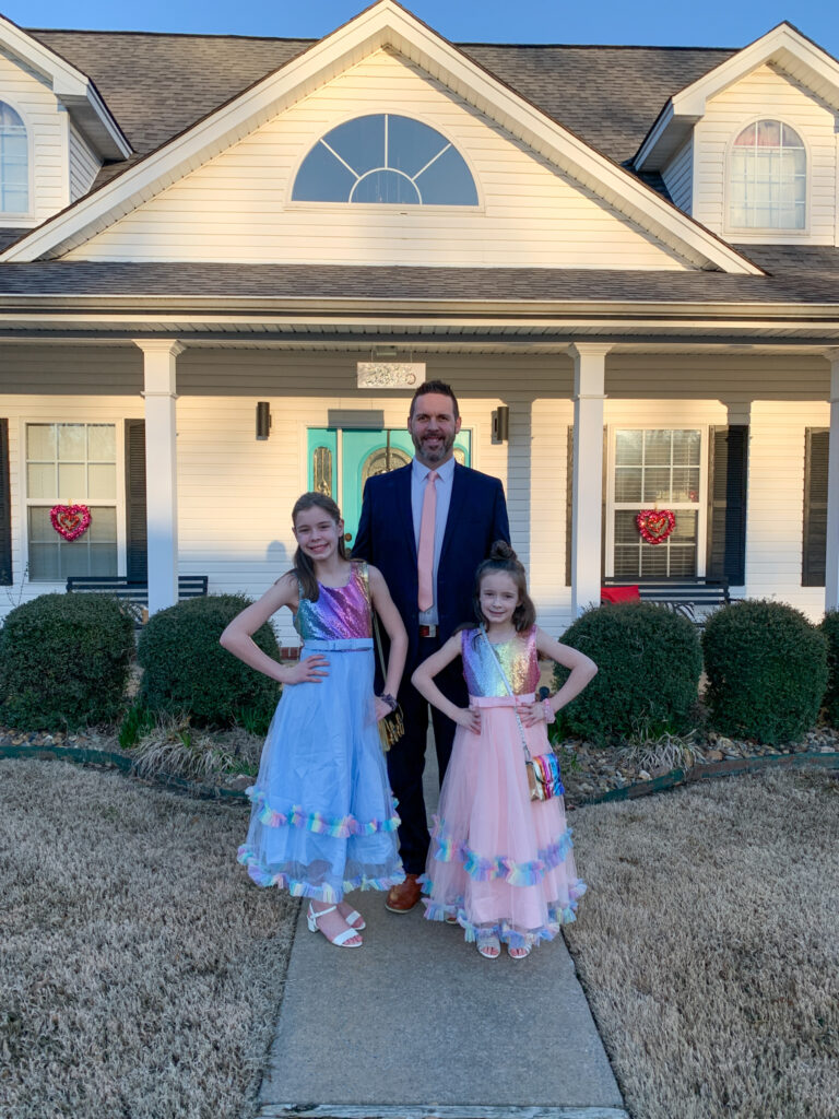 father and daughters pose in daddy daughter dance clothing