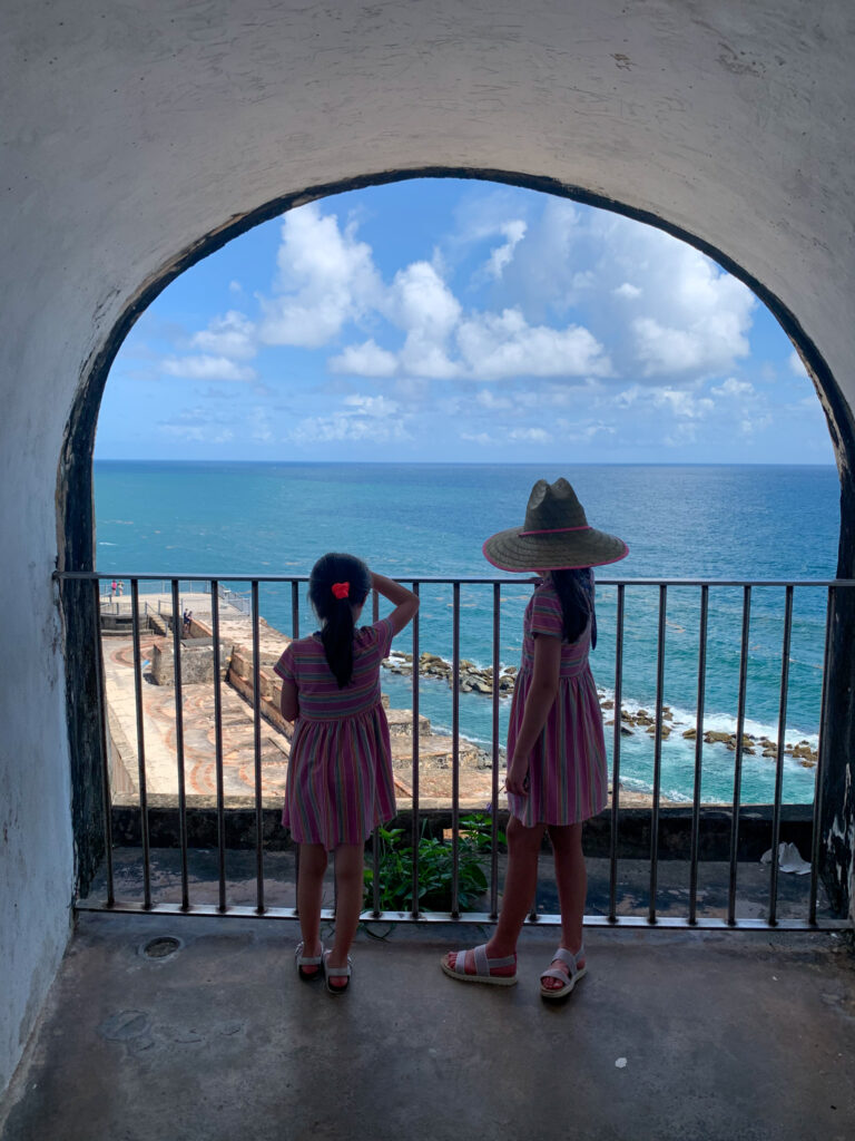 Arkansas Girls, Norah and Harper, looking out window of El Morro in San Juan, Puerto Rico