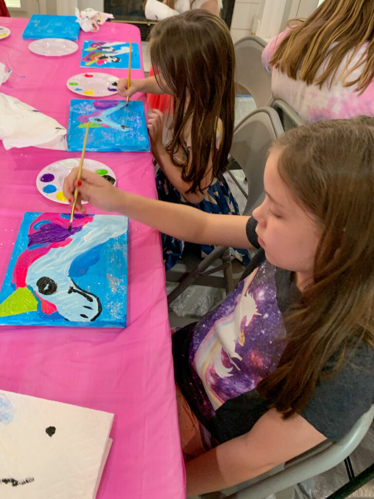 two girls hard at work at a unicorn paint party