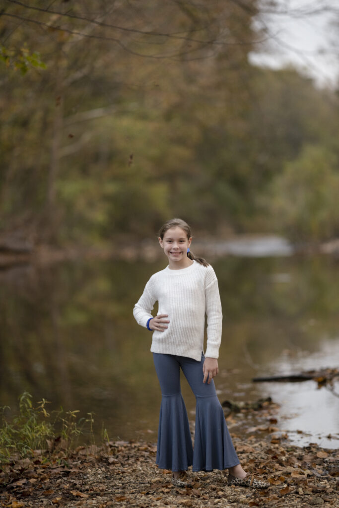 kid blogger, Harper from Arkansas Girls, stands in front of the Saline River