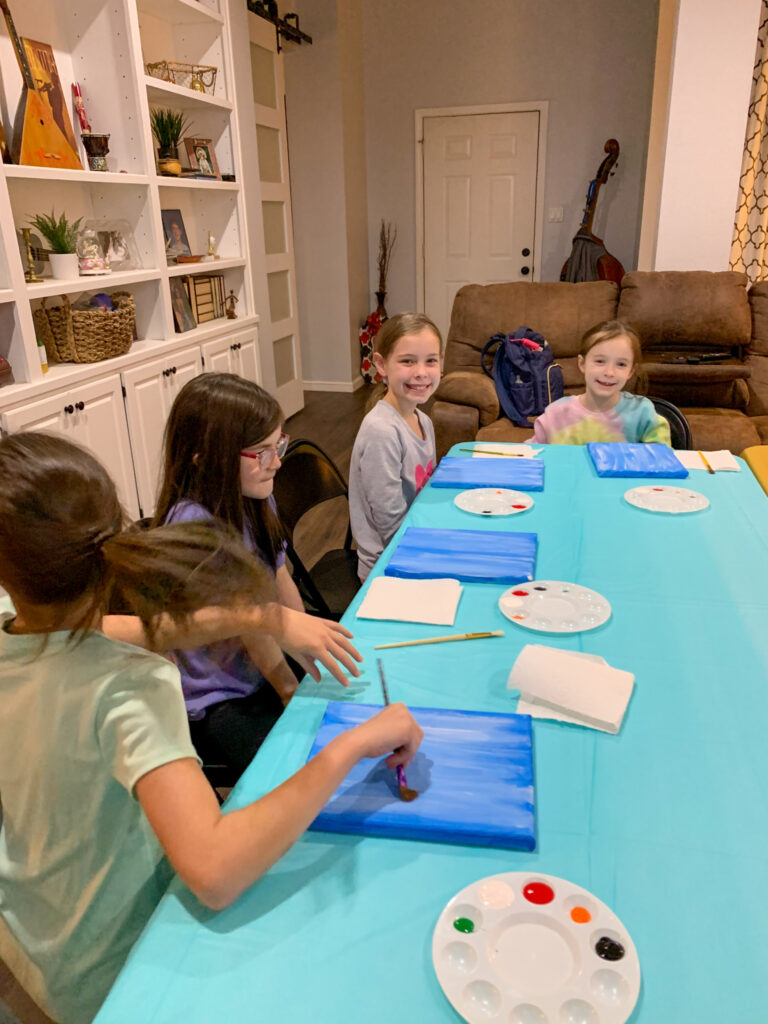 children waiting at table with a blue cover