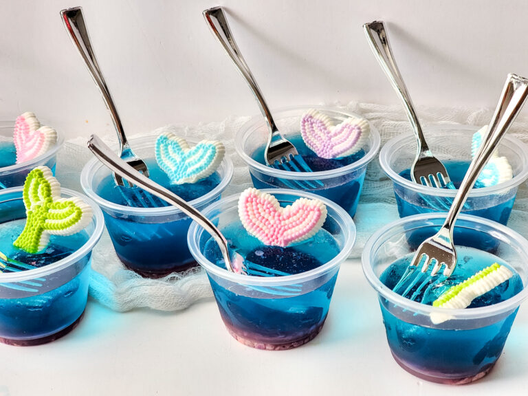 blue ocean cups (Mermaid Jello cups) in plastic cups with Dinglehopper forks and mermaid tails candy on top