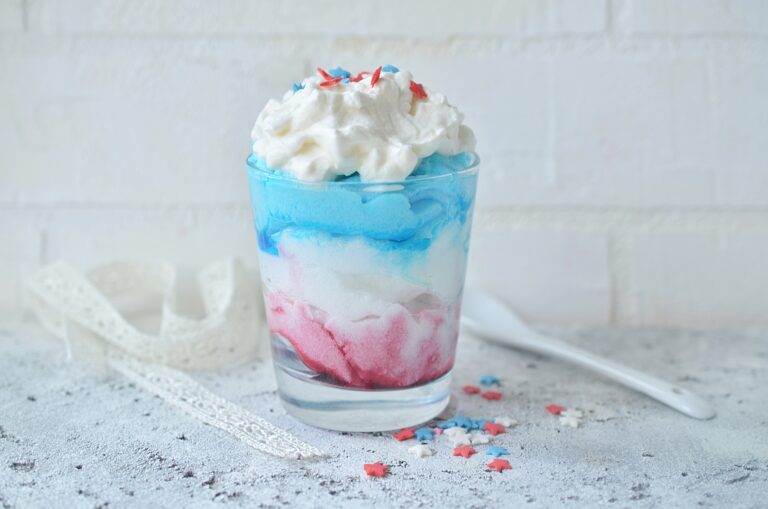 Fourth of July milkshake in red, white, and blue with a spoon to the right