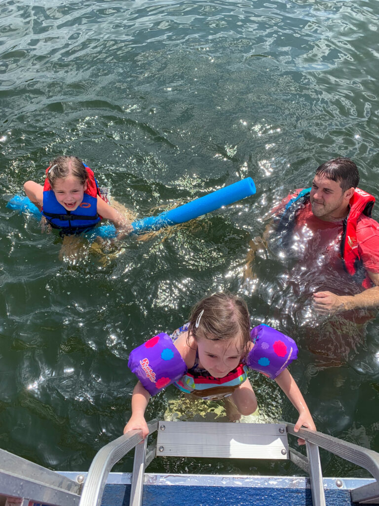 kids doing outdoor activities in Arkansas at Lake DeGray - climbing onto boat with Dad