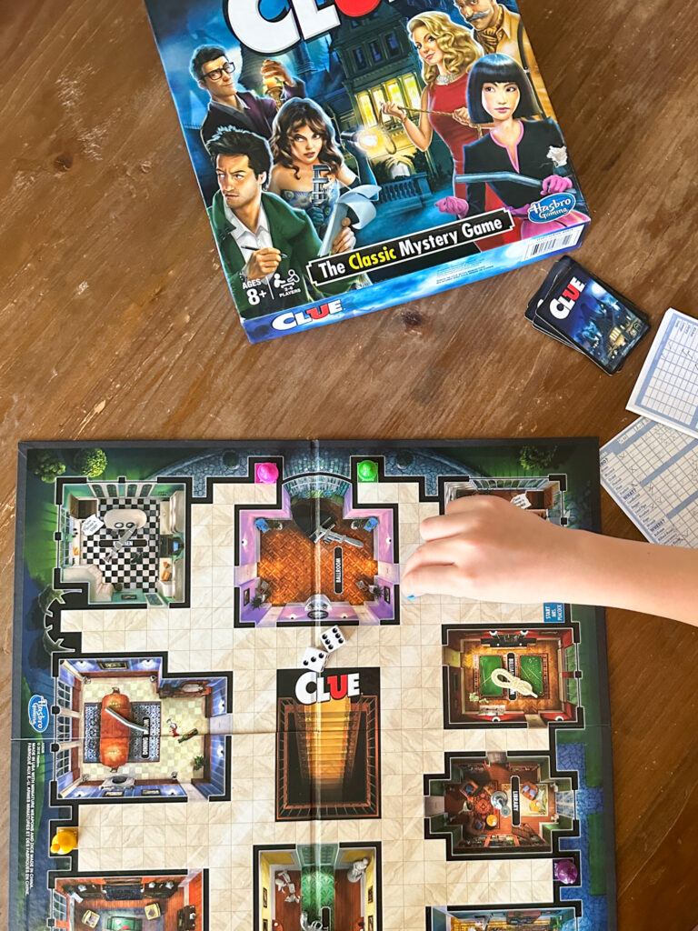 child playing a pawn in Clue for best board games for 8 year olds