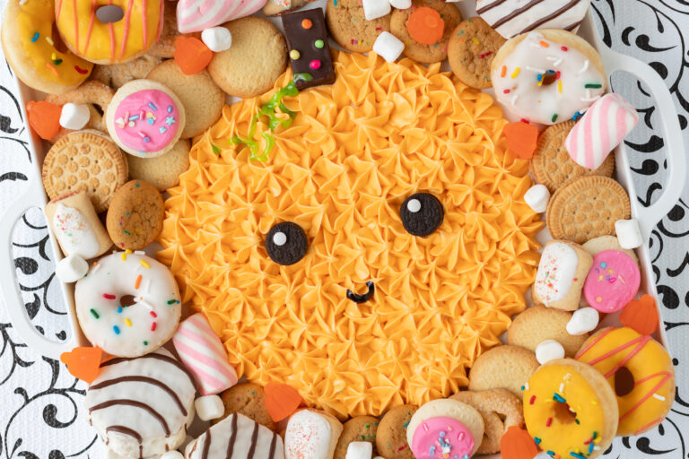 orange pumpkin frosting board with cookies and donuts