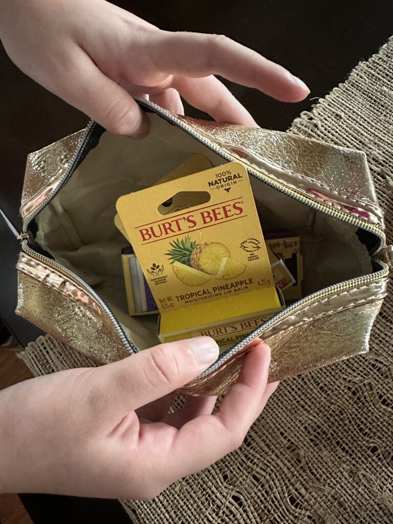 girl putting together teacher gift of lip balm with teacher gift tag