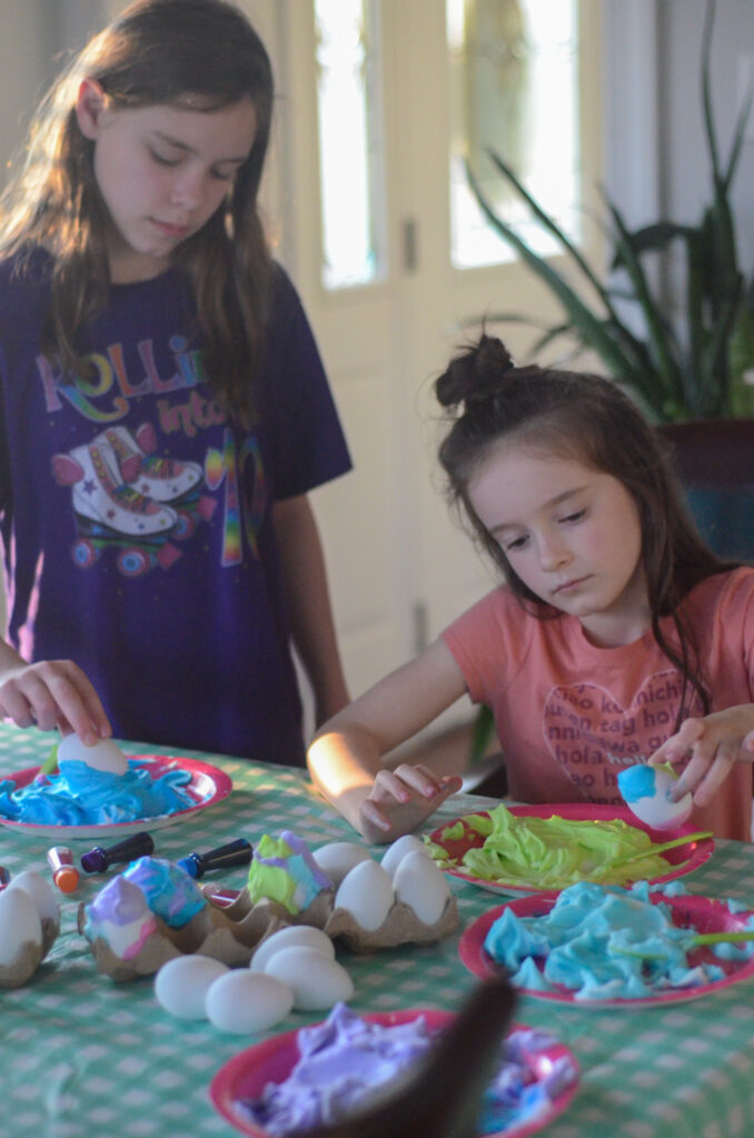 Arkansas Girls, Harper and Norah, working on food coloring Easter eggs with whipped cream