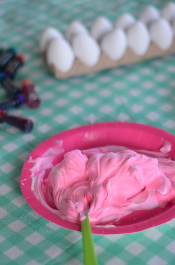 plate of pink food colored whipped cream for Easter eggs