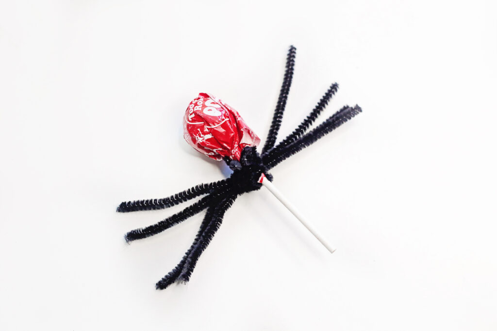 the start of Halloween pipe cleaner spider lollipops craft on table