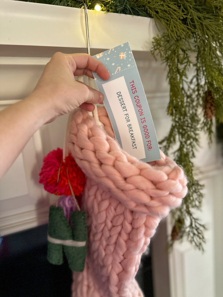 woman slides free printable Christmas coupons into stocking for stocking stuffers