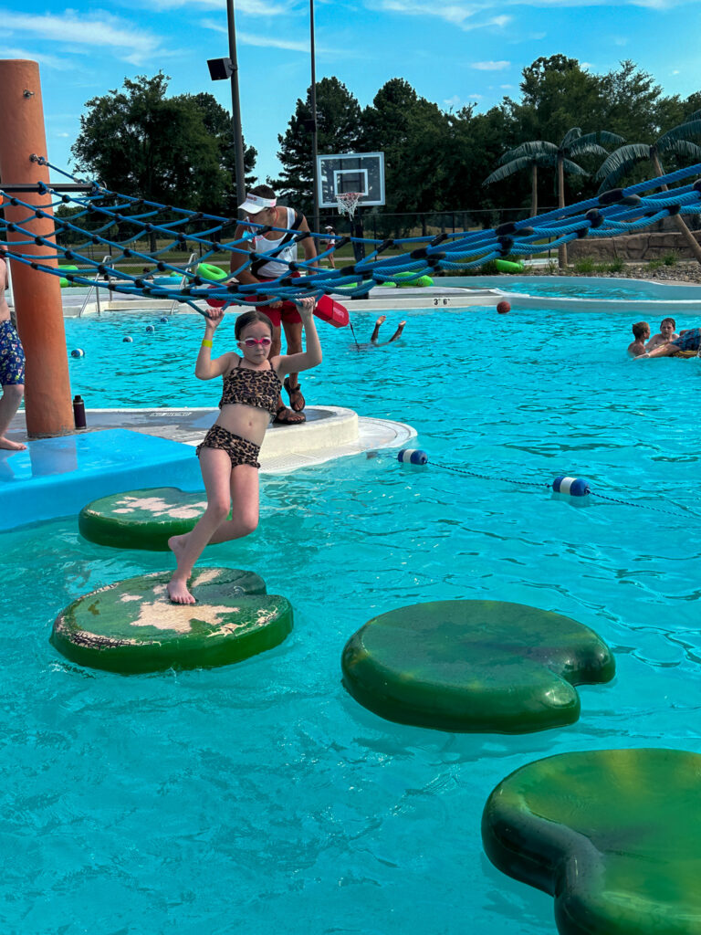 little girl on the lily pad activity at Parrot Island Waterpark in Fort Smith
