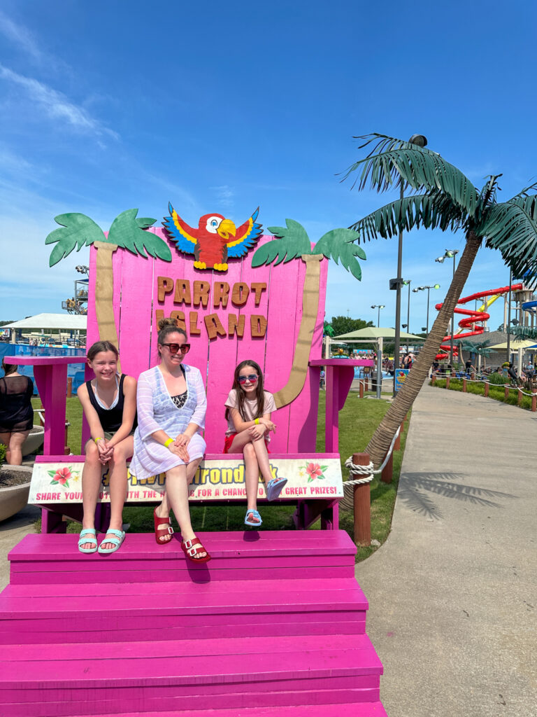 Arkansas bloggers sit on pink chair at Parrot Island Waterpark in Fort Smith, Arkansas