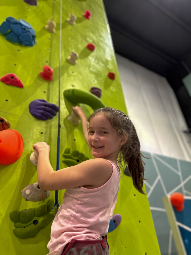 Arkansas tween blogger, Norah, climbing a rock climbing wall