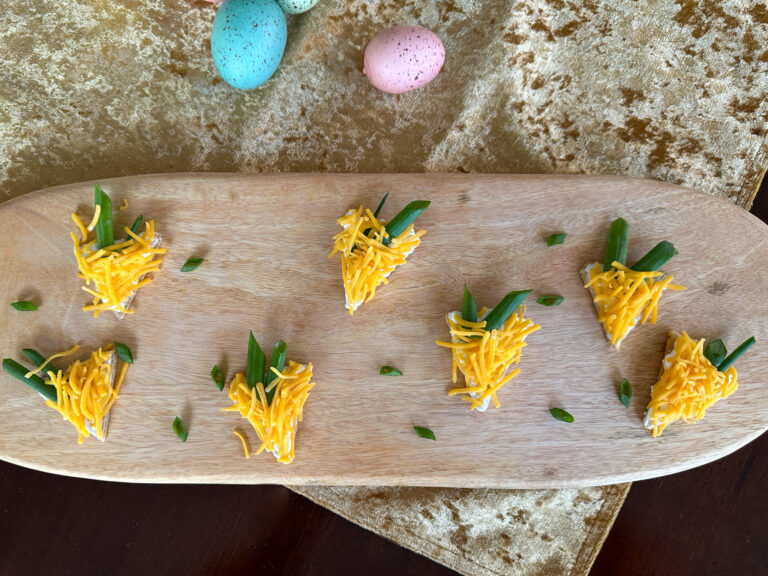 Easter cheese and crackers shaped like carrots on wooden board